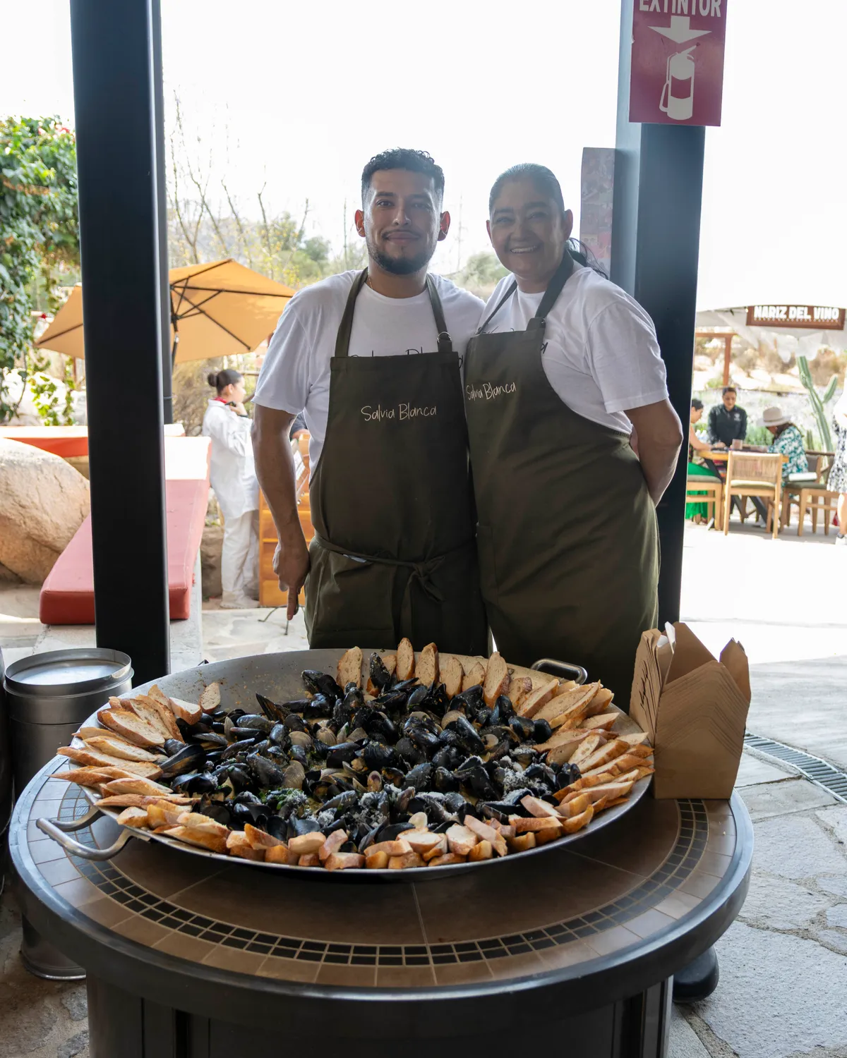 El equipo de Salvia Blanca con una paellera de mejillones y pan en la vendimia