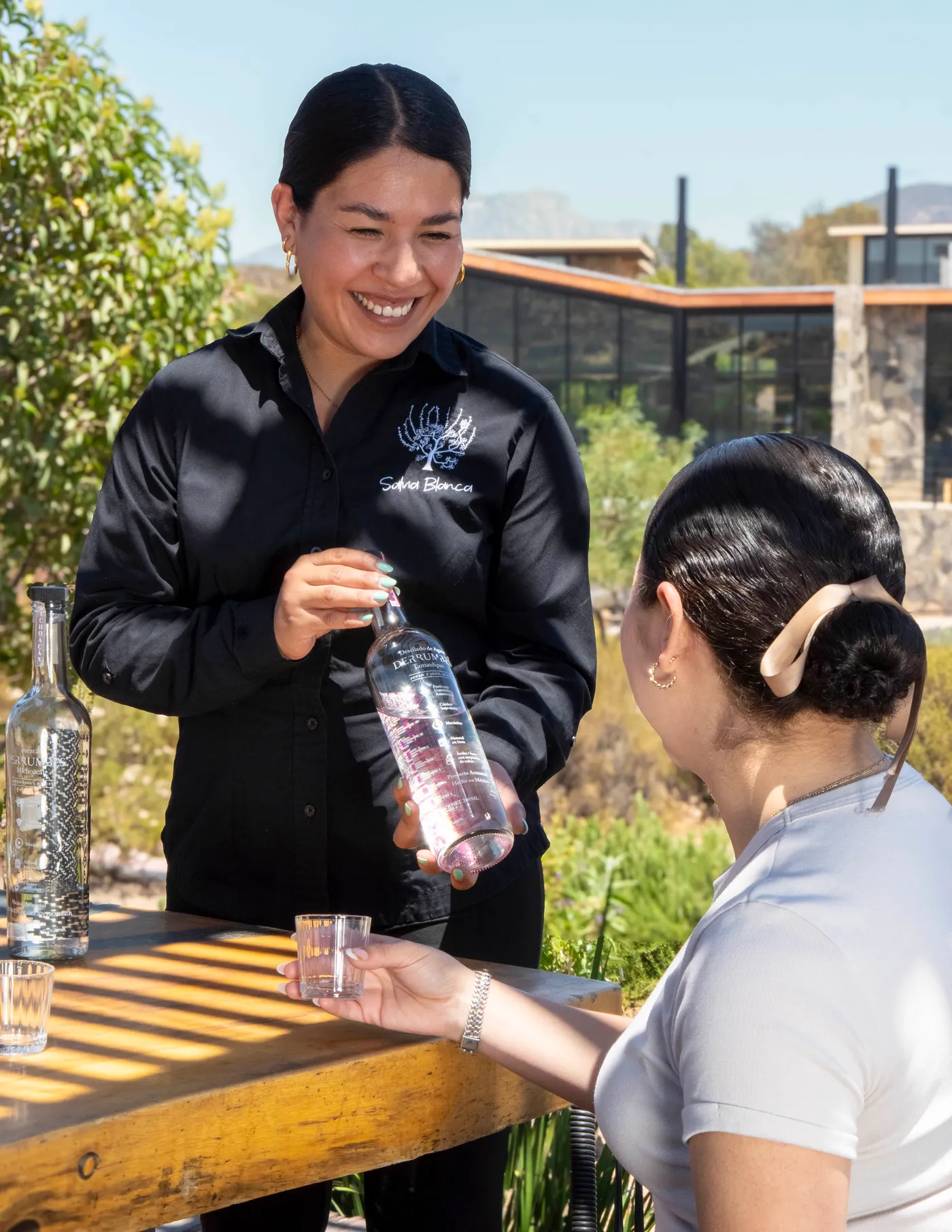 Anfitriona de Salvia Blanca presentando un mezcal durante una cata