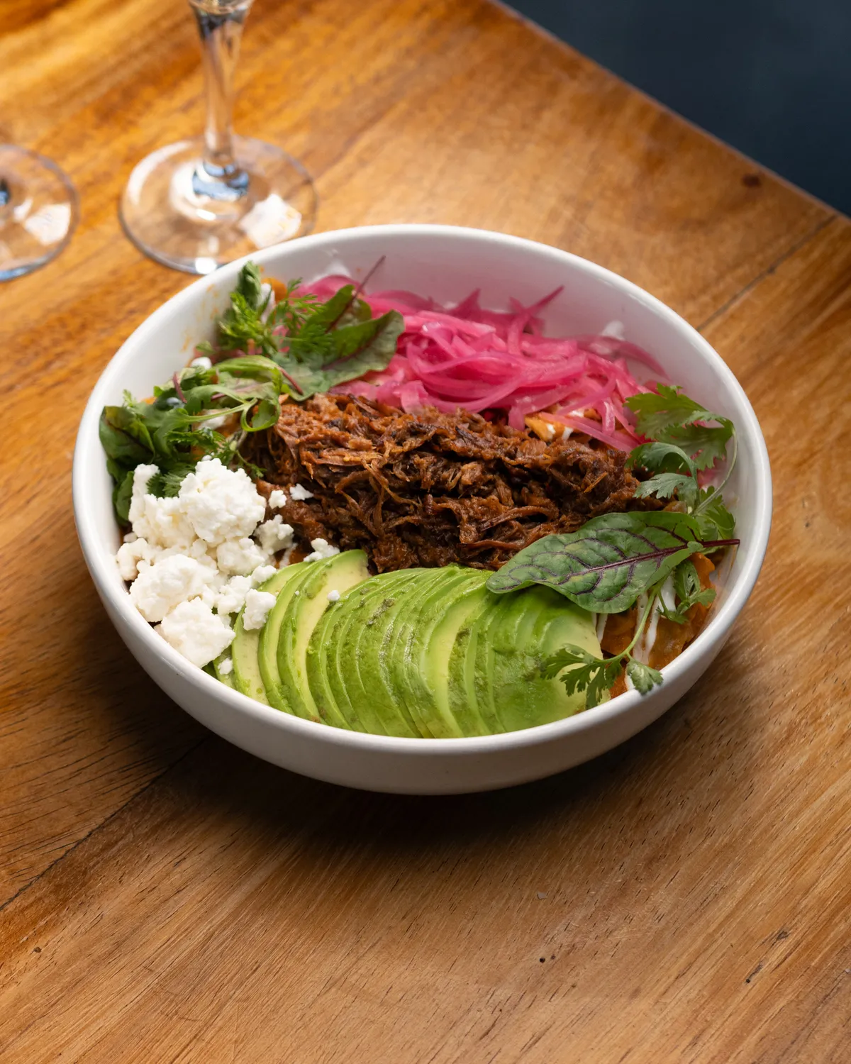 Chilaquiles de borrego con aguacate, queso fresco y cebolla morada