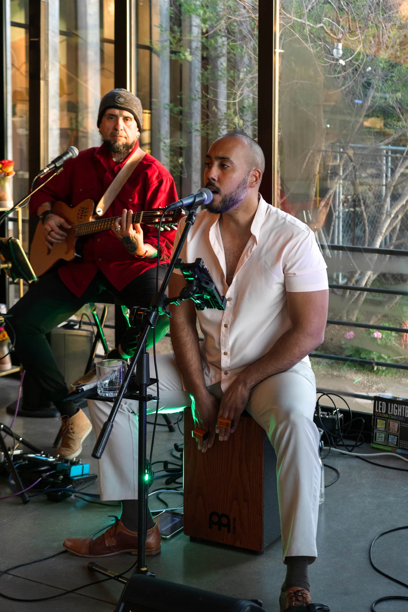 Dos músicos tocando en vivo en el salón de Salvia Blanca